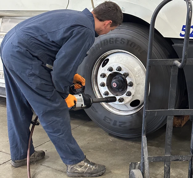 A mechanic replacing a truck's tire